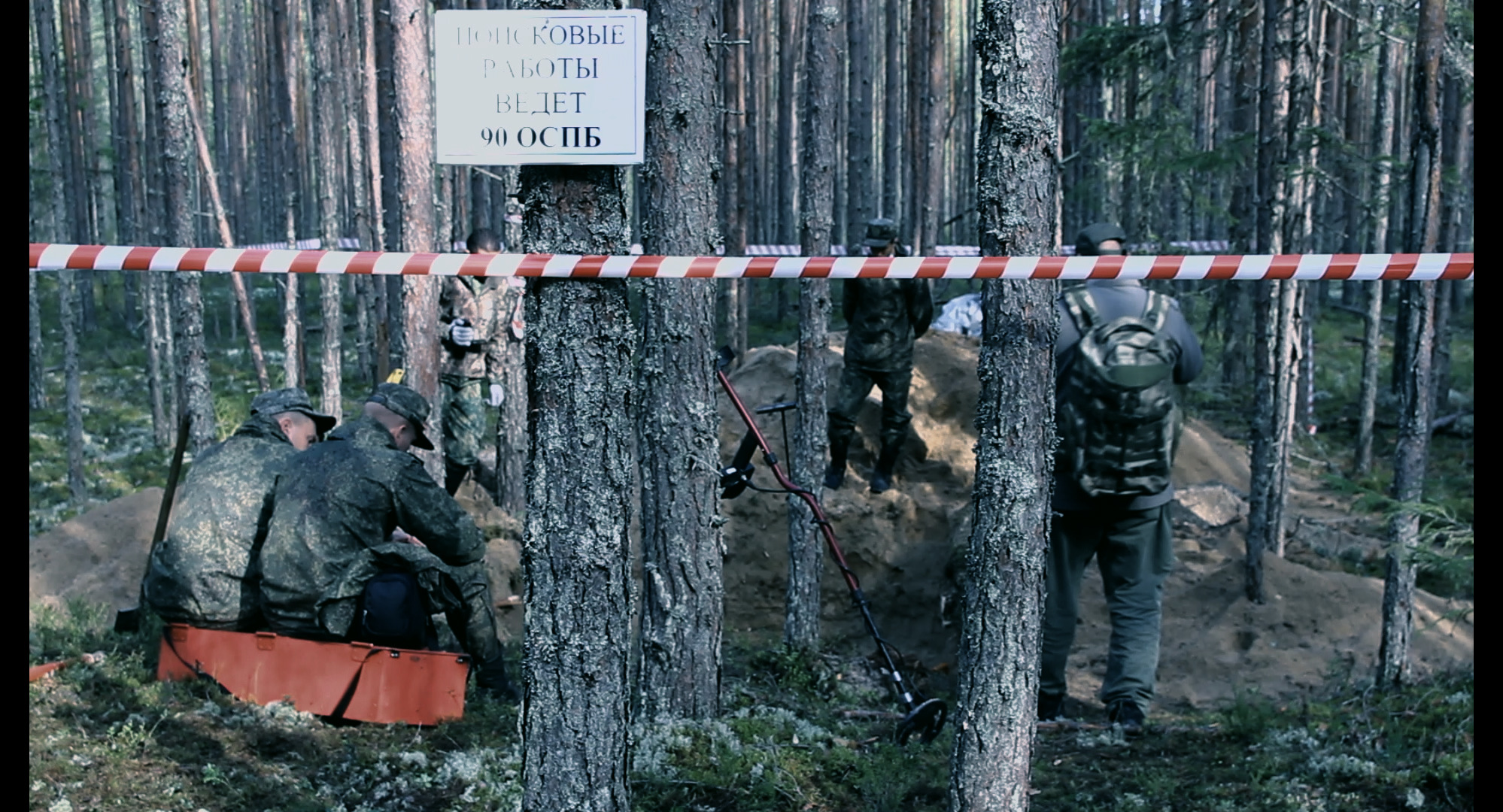 skupina ruských vojáků ohledává masový hrob v lese